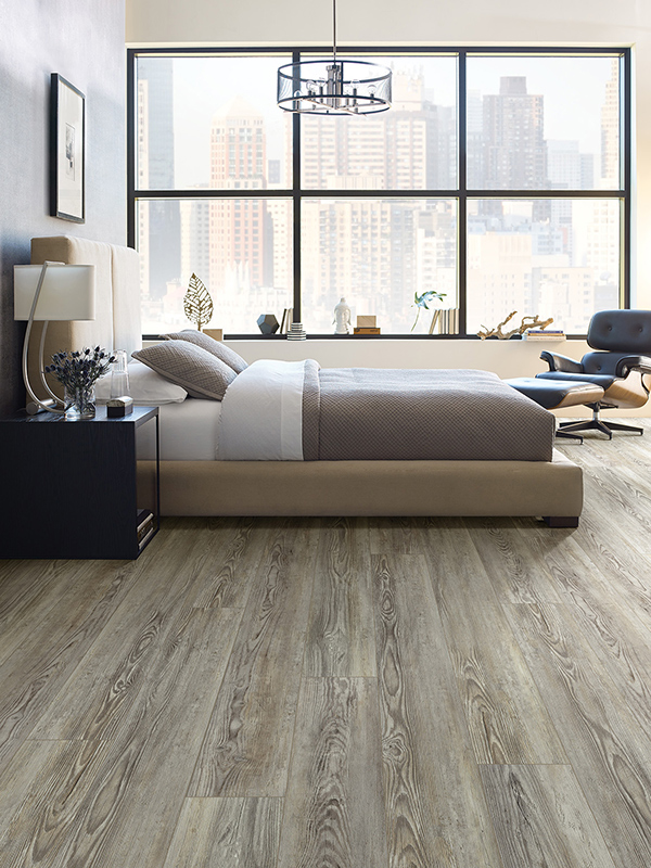 Bedroom filled with natural light that has a soft grey floating floor.